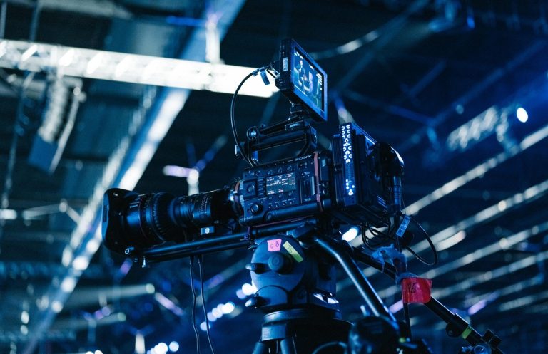 Hybride Veranstaltungen Eine Kamera auf einem Stativ in einer modernen, beleuchteten Umgebung.